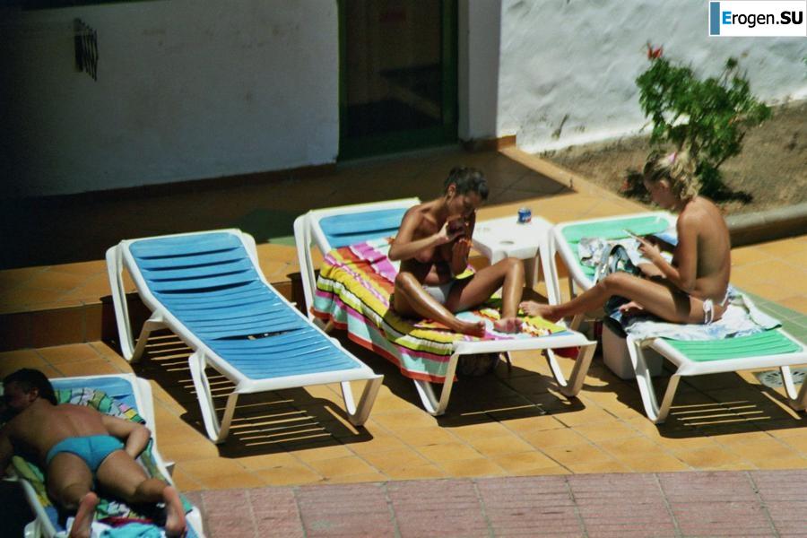 Girls sunbathe topless near the pool. Photo 1