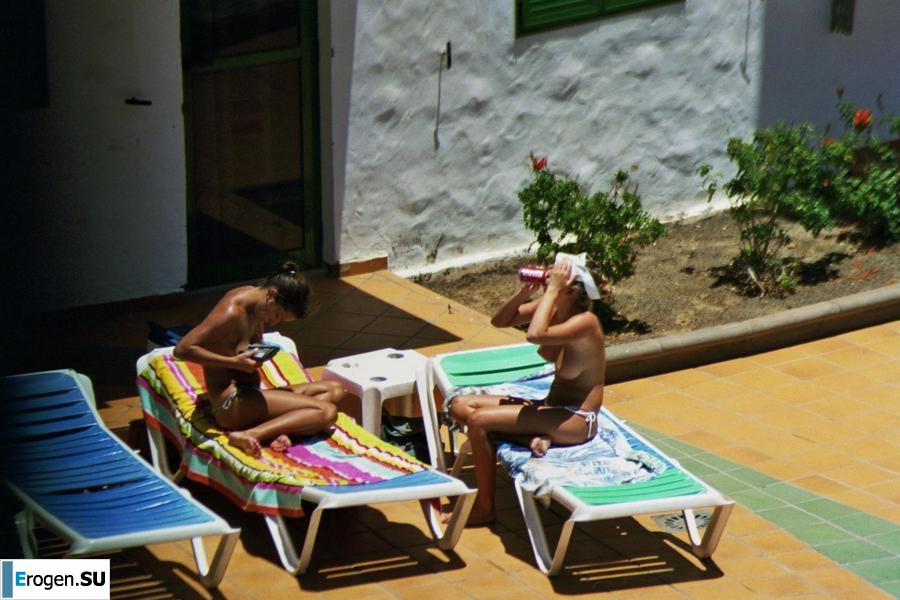 Girls sunbathe topless near the pool. Part 2. Slide 1