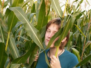 A thin student pleases herself with corn right in the field. Thumb 2